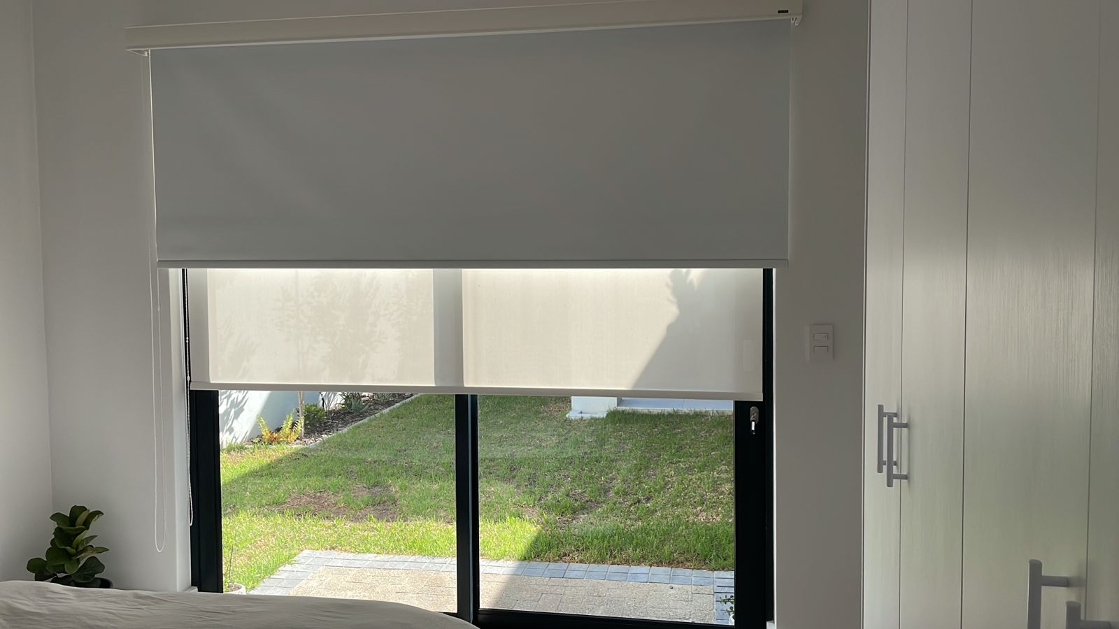 White double roller blinds bedroom garden view