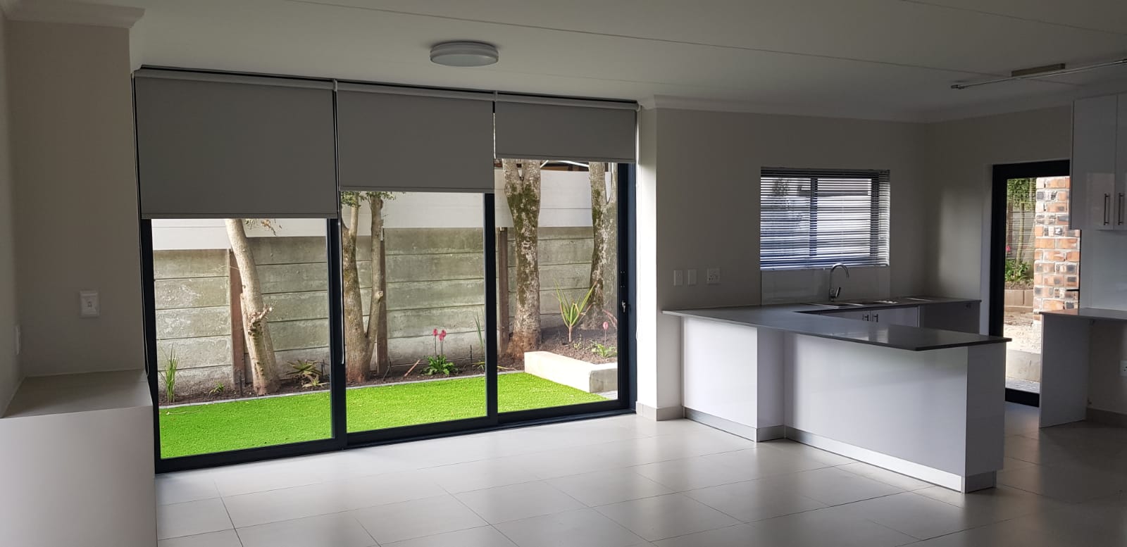 Open-plan kitchen grey roller blinds